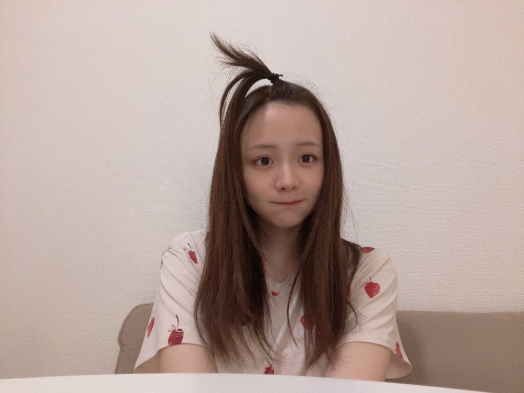 "森香澄が頭頂部でポニーテールにしたラフなヘアスタイルで、いちご柄のTシャツを着てカメラを見ている