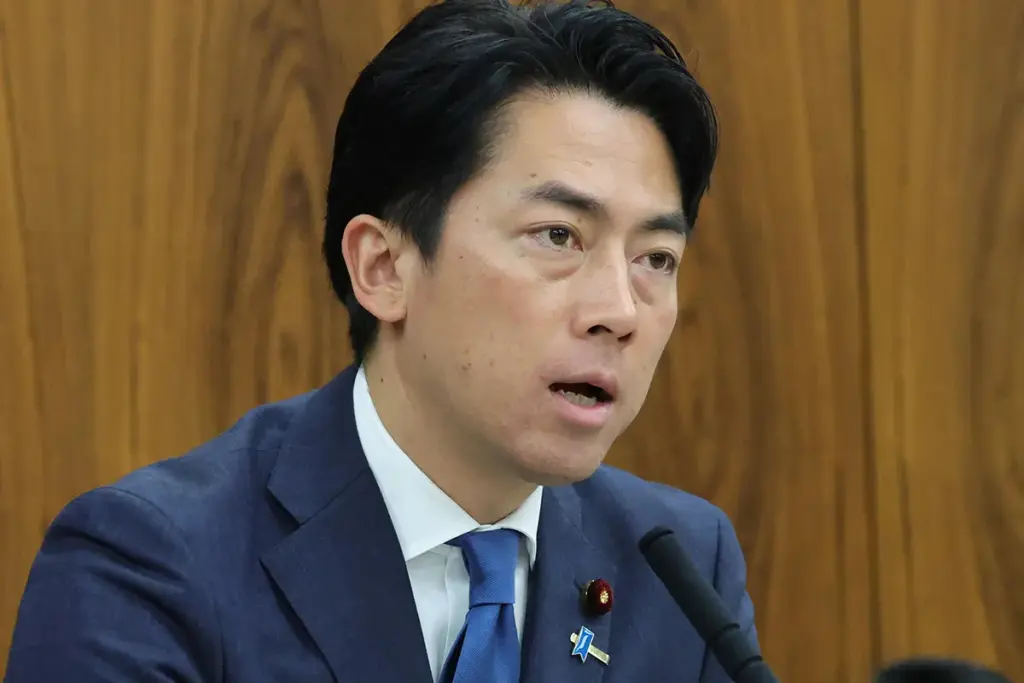 "スーツ姿の小泉進次郎氏が、マイクを前に真剣な表情で発言している。"