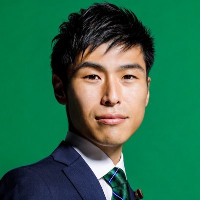 背景が緑色の山添拓氏の正面写真