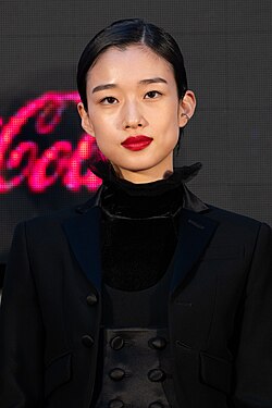 "東京国際映画祭のレッドカーペットに登場した際の女優・河合優実さん。黒いドレスと赤いリップが印象的。"