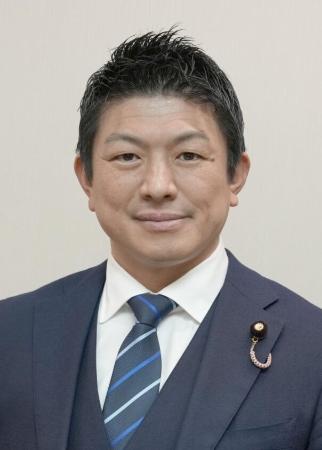 この画像に写っている方は、おおよそ40代から50代の男性であると推測されます。また、服装から、公的な場やビジネスシーンにいらっしゃる方だと考えられます。顔立ちの特徴としては、目元がはっきりとしており、全体的にしっかりとした印象を受けます。髪型も短く整えられており、清潔感があります。