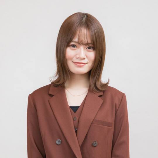 茶色のジャケットを着用し、微笑んでいる日本人女性のポートレート。