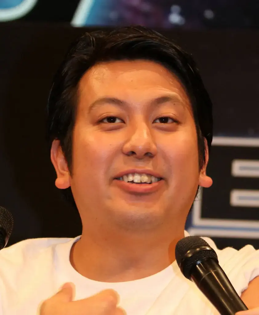 マイクの前で話すレインボーのジャンボたかお
