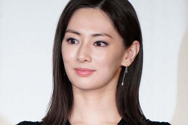 黒髪の美しい日本人女性が、はっきりとカメラ目線で、穏やかな微笑みを浮かべている上半身の画像