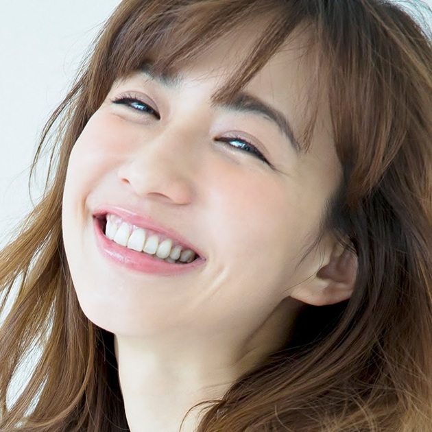 茶色い髪の女性が、白い歯を見せて明るく笑っている顔写真です。親しみやすく、快活な印象を与えます。