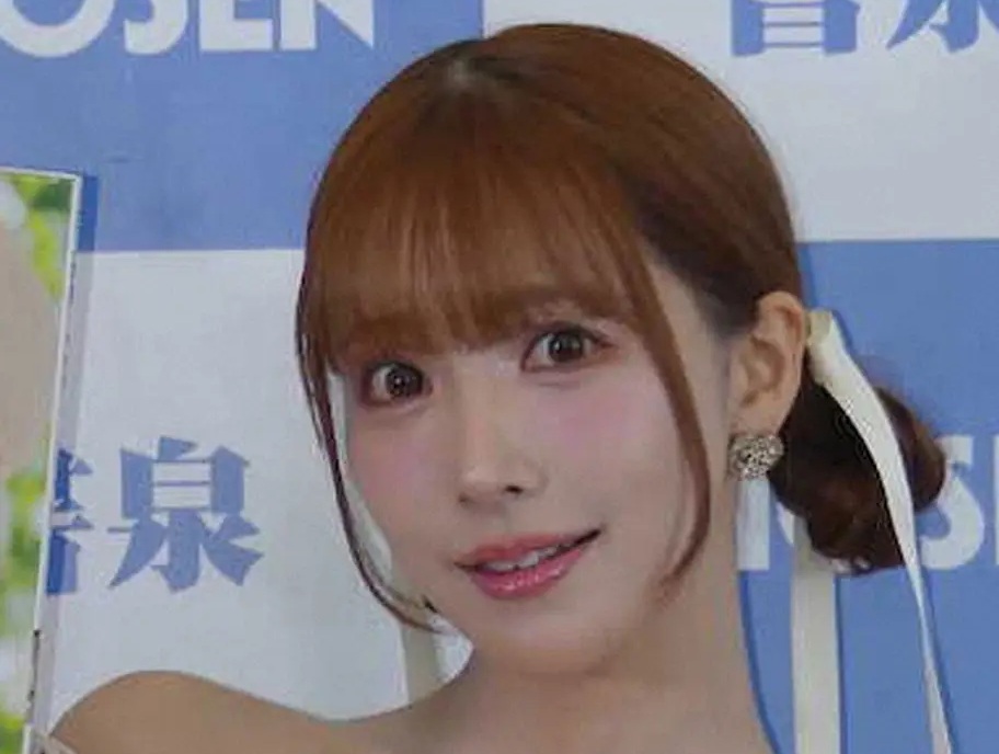 明るい茶髪で、ピンク色のリボンをつけた女性の顔のアップ。