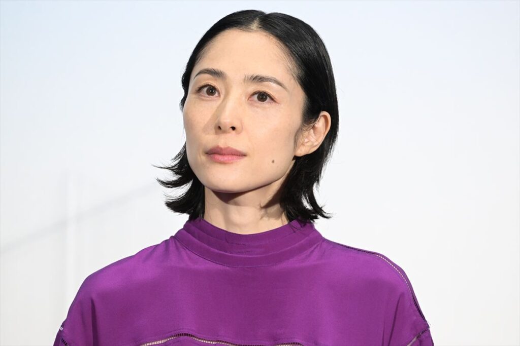紫色の服を着て正面を見つめる女優の深津絵里さん