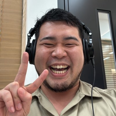 ヘッドフォンを付けて笑顔でピースサインをする令和ロマンの松井ケムリさん