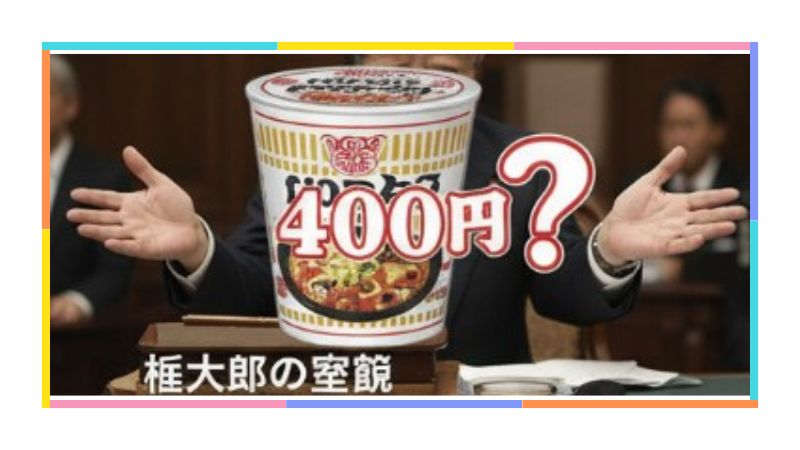 麻生太郎氏の前に巨大なカップ麺と「400円？」の文字があり、庶民感覚とのズレを表現。