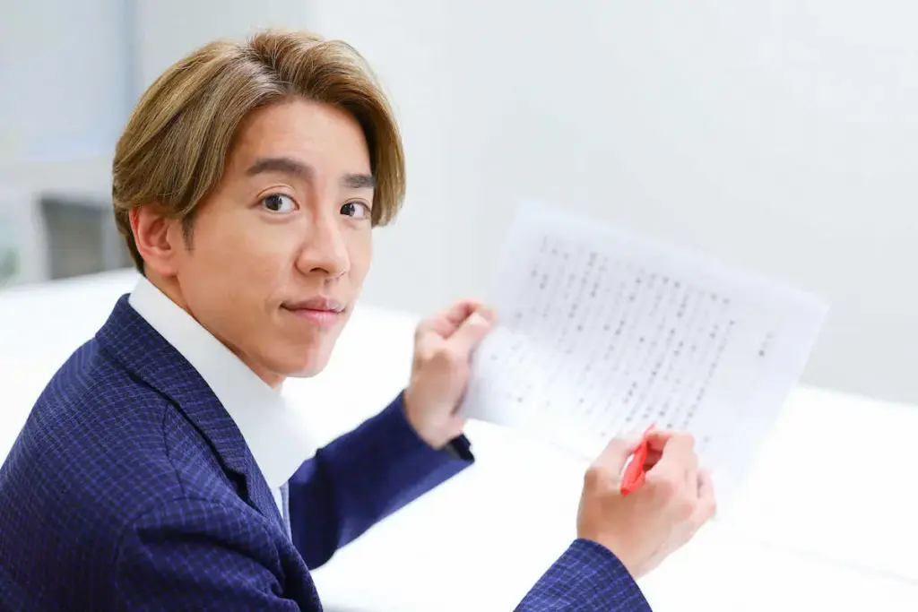 正面を向いて書類を持つ村上信五さんのポートレート。真剣な表情でカメラを見つめている。