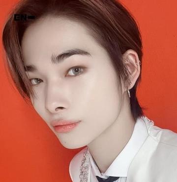 ENHYPENのニキさんの顔のアップ写真。オレンジ色の背景。