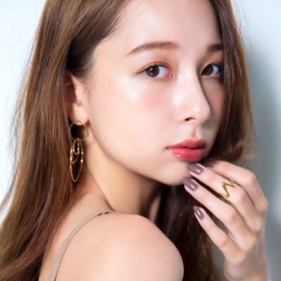 茶色のロングヘアで、金色のイヤリングと指輪を着用した丹羽仁希さんのポートレート