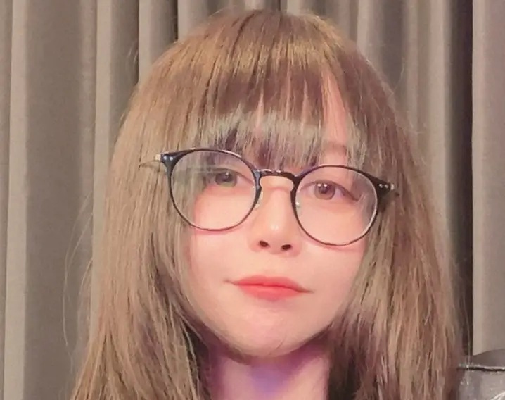 元プロゲーマーでストリーマーのたぬかなの顔写真。茶髪に丸いメガネをかけた女性のクローズアップ画像