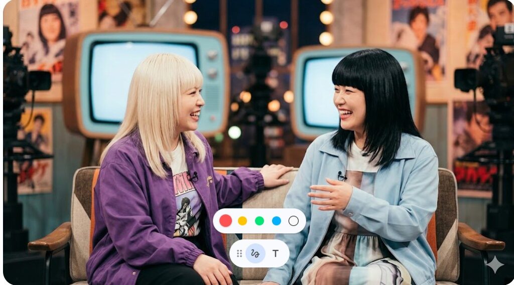 テレビ番組のセットのような場所で、ソファに座り楽しそうに談笑する二人の女性